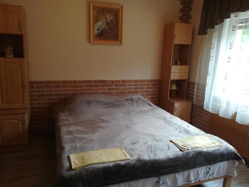 a bed in a room with a brick wall at Pensiunea Colt Alb in Băile Homorod