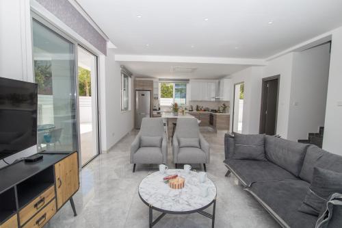 a living room with a couch and a table at Fig Tree Bay Residences 1 Lantiana Villa in Protaras