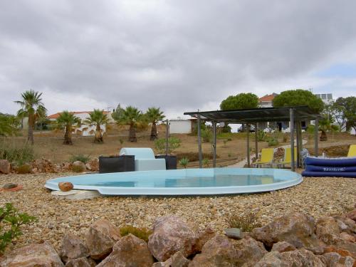 uma piscina circular num quintal com um gazebo em Quartos Com Boas Vistas em Ribeira da Gafa