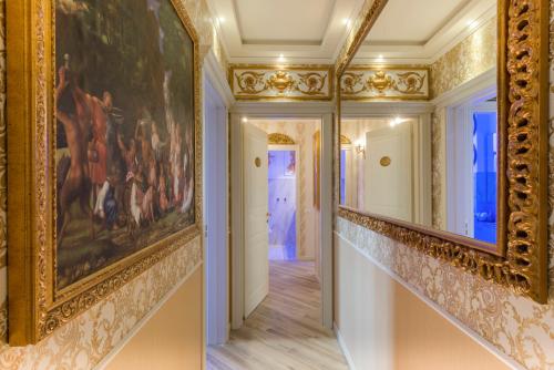 two pictures of a hallway with a painting on the walls at Royal Olympus Verona in Verona