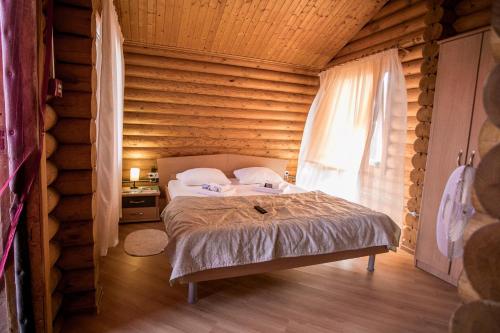 a bedroom with a bed in a log cabin at Частный дом Elisa Sarkau in Lesnoy