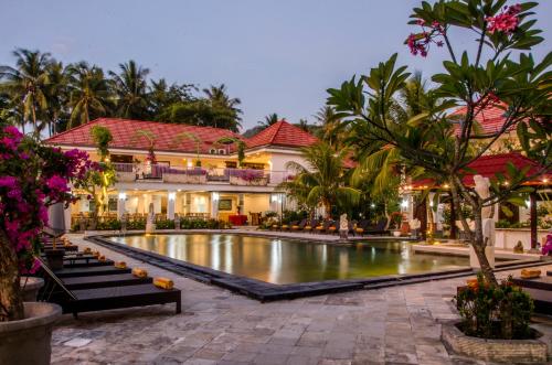 a resort with a pool in front of a building at Puri Saron Senggigi Hotel in Senggigi