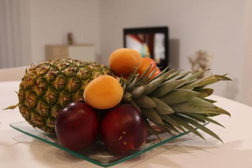 a bowl of fruit with apples and oranges on a table at Apartman F&F in Otočac