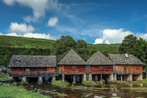 a group of wooden houses in a field at Apartman F&F in Otočac