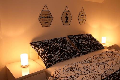 a bedroom with a bed and two night stands with candles at Apartman F&F in Otočac