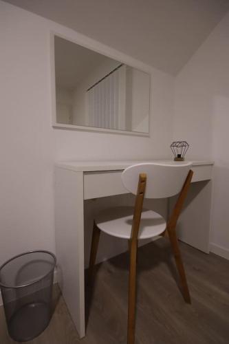 a white desk with a chair and a mirror at Apartman F&F in Otočac