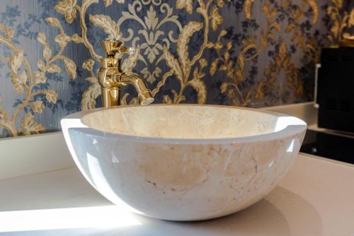 a sink with a gold faucet in a bathroom at Royal Olympus Verona in Verona