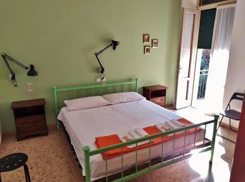 a bedroom with a bed with a green frame at Ostello delle cartiere in Toscolano Maderno