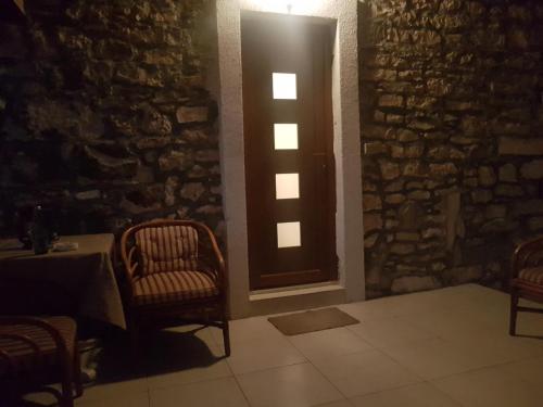 a room with two chairs and a table and a door at Vila Dora Supetar in Supetar