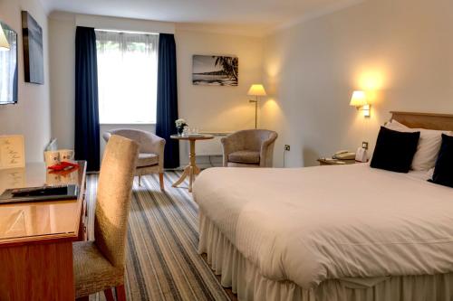 a hotel room with a bed and a table at Best Western Plus Bentley Hotel in Lincoln