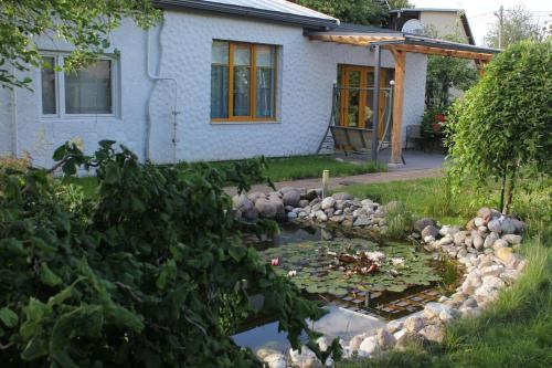 斯伽爾達的住宿－Sigulda City Center Holiday House，一座花园,花园前方有一座养着百合花的池塘