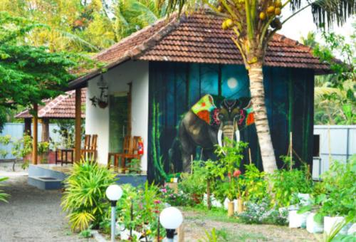 Una casa con una pintura de un elefante delante de ella. en Nettle Trees Farm Stay, en Alleppey