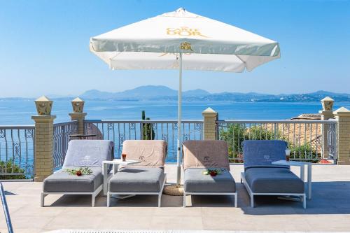 a group of chairs and an umbrella on a deck at Locanda Barbati Luxury ApartHotel in Barbati