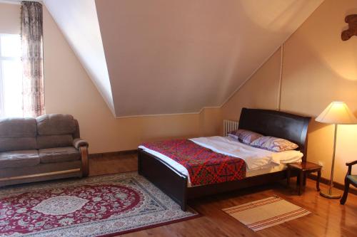 a small bedroom with a bed and a chair at Tagaytay Karakol Hotel in Karakol
