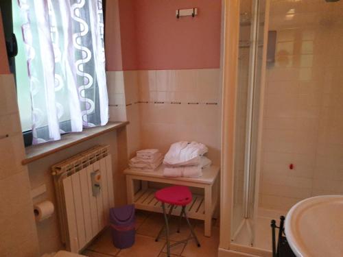 a bathroom with a sink and a stool next to a shower at B&B Land & Sea in Campofilone