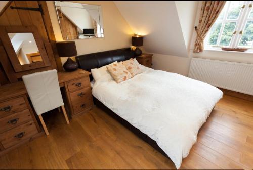 a bedroom with a large bed and a mirror at Hanger Down House Bed and Breakfast in Arundel