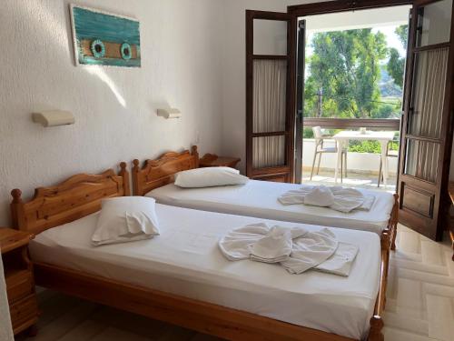two beds in a room with a window at Villa Spartias in Skiathos