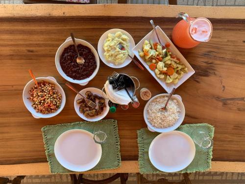 a table with bowls of food and plates of food at Latica Lodge in Playa Negra