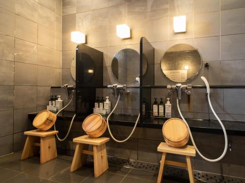 a bathroom with two sinks and two mirrors at Super Hotel Kushiro-Ekimae in Kushiro