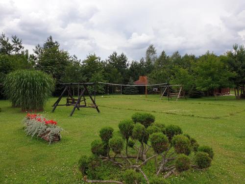 a park with a swing set in the grass at Domki nad Sanem in Lesko