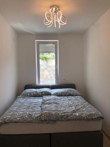 un letto in una camera da letto con lampadario a braccio di Apartment Zeljkica - Villa Sunce a Senj