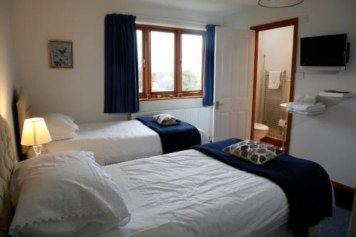 Habitación de hotel con 2 camas y ventana en Two Hoots Bed and Breakfast, en Brackley