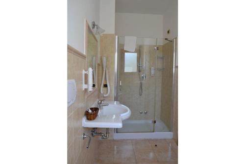 y baño con lavabo y ducha. en B&B "Bilha Hotel", en Le Castella