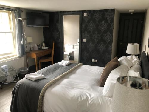 A bed or beds in a room at Linden House Stansted 