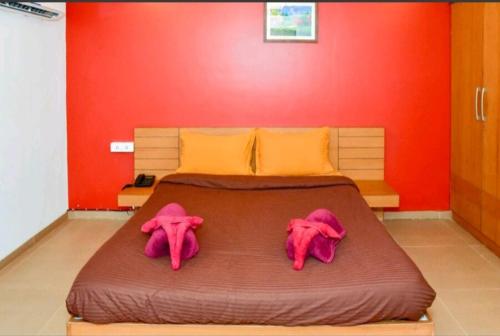 a bed with two pink stuffed elephants on it at Surya Kiran Miramar in Panaji