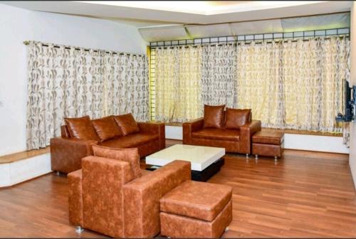 a living room with couches and a couch and a table at Surya Kiran Miramar in Panaji