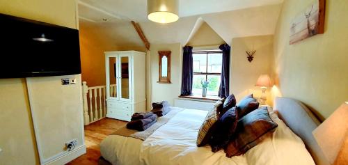 a bedroom with a bed and a television in it at Hill End Cottages in Warslow