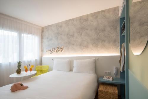 - une chambre avec un grand lit blanc et une fenêtre dans l'établissement ibis Styles Nice Cap 3000 Aéroport, à Saint-Laurent-du-Var