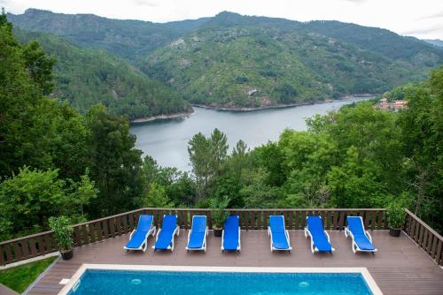 a group of blue chairs sitting on a deck next to a pool at Casa Encosta do Gerês-Ferias no Gerês in Vieira do Minho