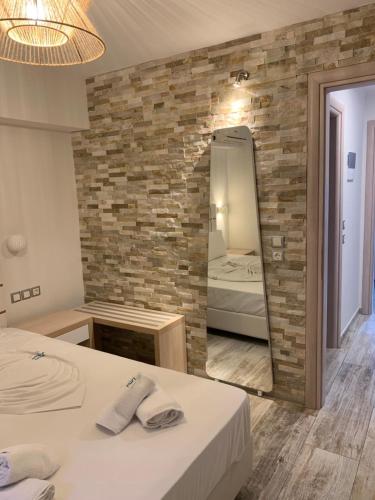 a bedroom with a brick wall and a mirror at Litsa Apartments in Fourka