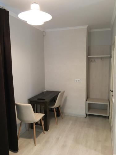 Cette chambre comprend un bureau, 2 chaises et une table. dans l'établissement Moonlight Hotel, à Chişinău