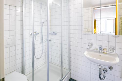 a bathroom with a shower and a sink at Hotel Old Town in Zurich