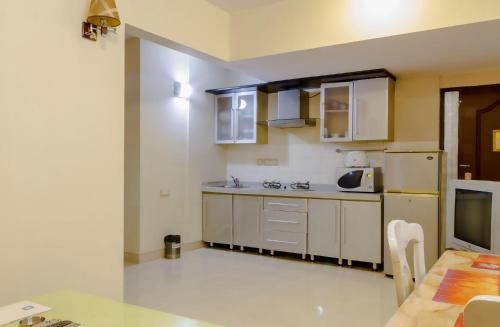 a small kitchen with white cabinets and a table at ASAR Landmark Suites in Mumbai