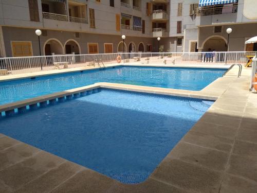 a large swimming pool in a large building at Apartamento Flamenco in Torrevieja