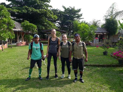 a group of people standing in the grass at Sumatra Cheeky Monkeys in Bukit Lawang