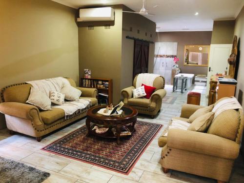 a living room with couches and a coffee table at Rooibos Retreat in Richards Bay