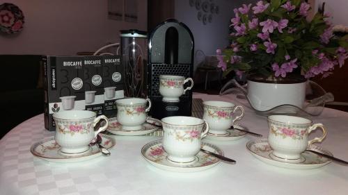 a table with four tea cups and saucers on it at S'Alighera Guest House in Alghero