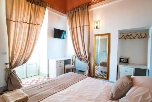 a bedroom with a bed and a large mirror at Borgo Cozzana in Monopoli