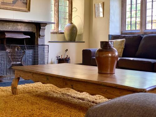 a living room with a coffee table with a vase on it at Riber Hall in Matlock Bank