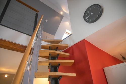 a clock on a wall next to a staircase at Das Nest am Park in Lemgo