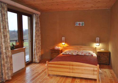 a bedroom with a bed and a large window at Gospodarstwo Pytlówka Sokalski Michał in Tarczek