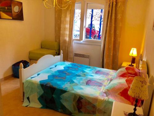 - un lit coloré dans une chambre avec fenêtre dans l'établissement 23 Rue Romain Rolland Appartement, à Collioure