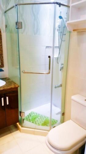 y baño con ducha y puerta de cristal. en ARC Home Rental at San Remo Oasis, en Cebú
