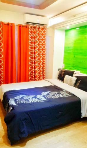 a bedroom with a bed with red and green curtains at ARC Home Rental at San Remo Oasis in Cebu City
