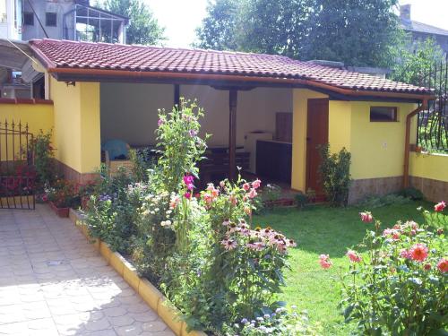 a small house with a garden with flowers at Къща за гости Фантазия in Tryavna