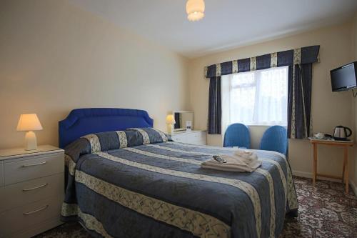 a bedroom with a blue bed and a window at Laguna Hotel in Bournemouth